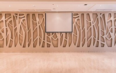 Conference room with decorative geometric wall panels, projection screen and polished flooring at Howard Johnson Plaza Buenos Aires.
