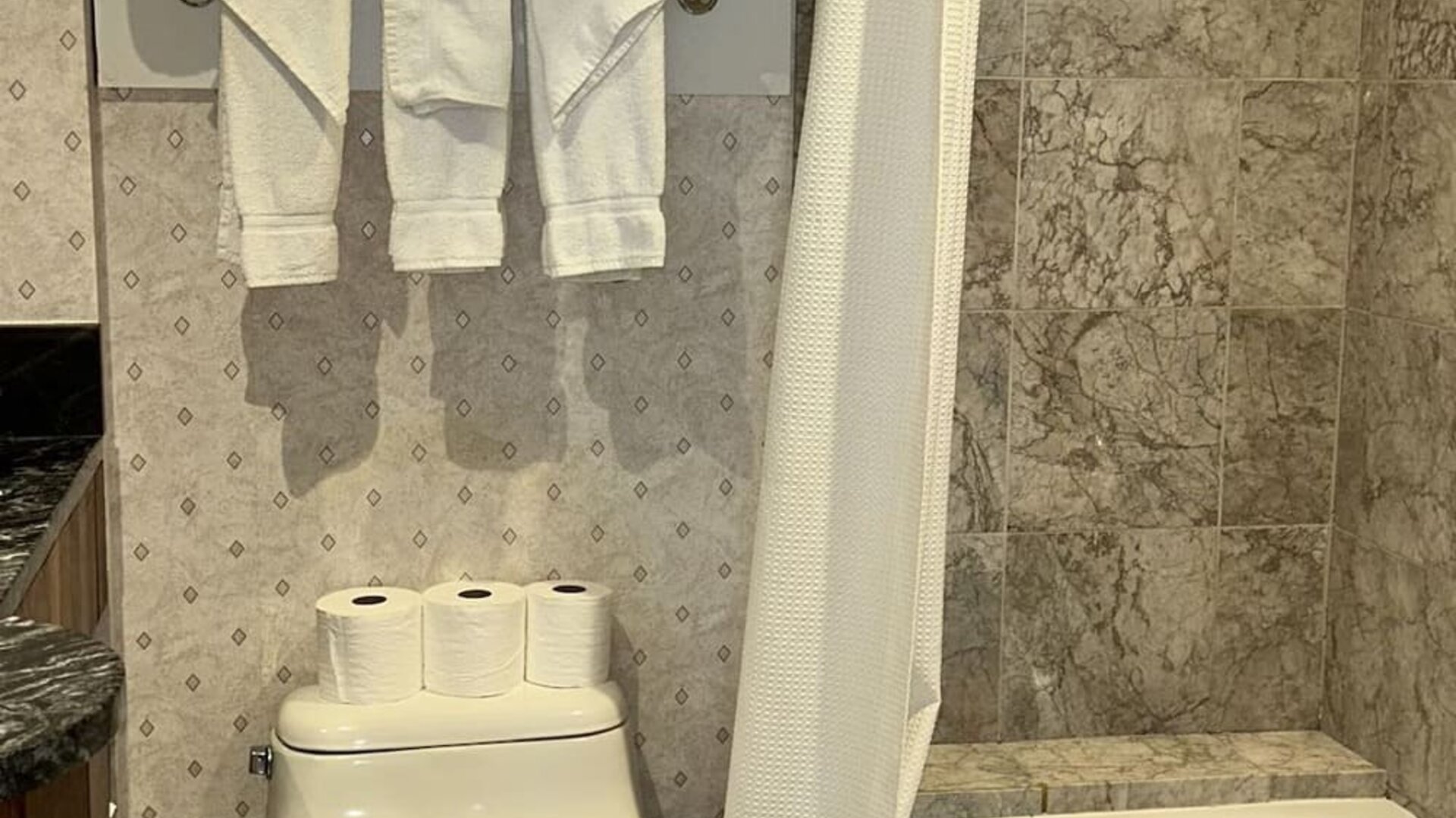 Private guest bathroom with tub at Parc Suites Hotel.