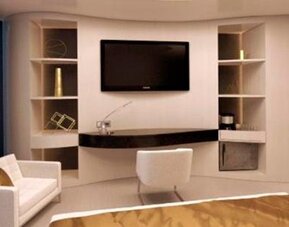 Contemporary guest suite with a wall-mounted television, cream seating, a desk and floor-to-ceiling windows at Hotel Las Américas Golden Tower Panamá.
