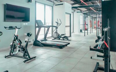 Fitness centre with stationary bikes, treadmills, strength equipment and a wall-mounted television at UMA Suites Chía.