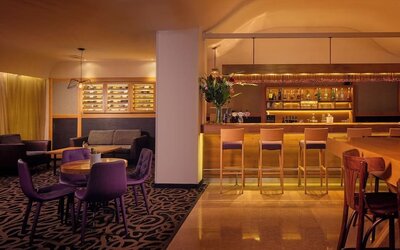 Hotel restaurant with booth seating, tables and chairs, decorative lighting, and a buffet counter in a spacious dining area at Prima Park Hotel.