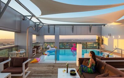 Rooftop pool with loungers, shaded seating, inflatable floats and city views at Prima Link.