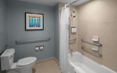 Accessible bathroom with bathtub, shower, toilet and grab bars at Hyatt Place Portland Airport at Cascade Station.