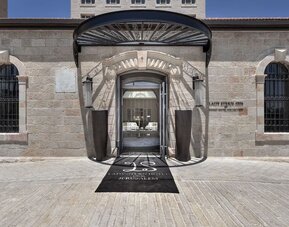 Main hotel entrance with stone façade, arched doorway and covered entrance canopy at Lady Stern Hotel.