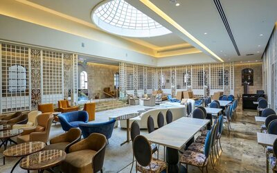 Dining area with tables, upholstered chairs and decorative lattice partitions at Lady Stern Hotel.