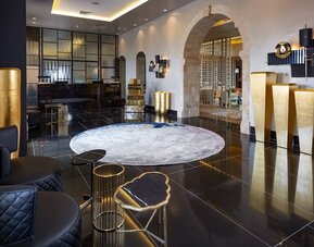 Concierge reception desk in a minimalist lobby with arched windows at Lady Stern Hotel.