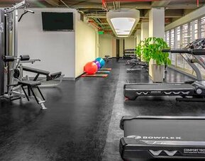 Fitness centre with treadmills, weight machines, free weights and exercise balls at Sonesta Hotel Bogotá.