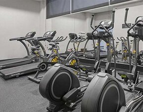 Fitness centre with treadmills, elliptical machines and exercise equipment arranged on a grey floor at City Express by Marriott CDMX La Villa.