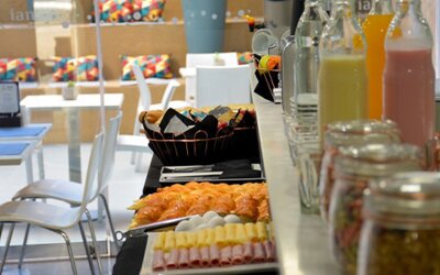 Breakfast buffet with pastries, sliced cold meats, juice bottles and jars of preserves beside dining tables at Ian Hotel.