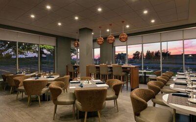 Restaurant area with comfortable seating at the Embassy Suites by Hilton Montreal Airport.