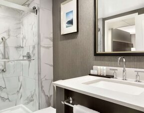 Private bathroom with shower at the Embassy Suites by Hilton Montreal Airport.
