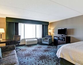 Day use room with TV, work desk and lounge area at Hampton Inn By Hilton Toronto Airport Corporate Centre.