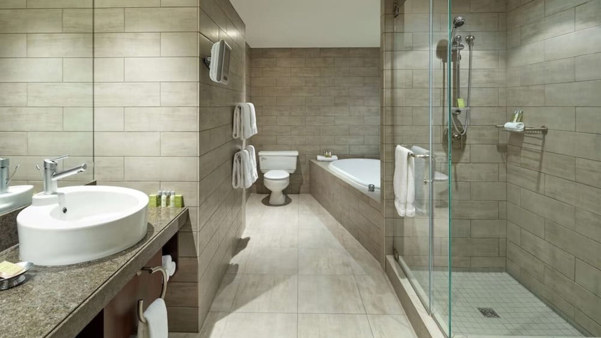 Private guest bathroom with shower, tub and free toiletries at DoubleTree By Hilton Montreal.