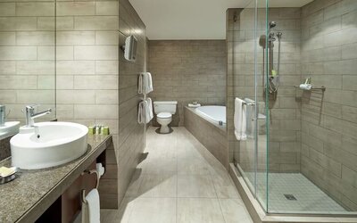 Private guest bathroom with shower, tub and free toiletries at DoubleTree By Hilton Montreal.