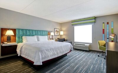 Bright day use room with king bed, work desk and private bathroom at the  Hampton Inn & Suites By Hilton Guelph.