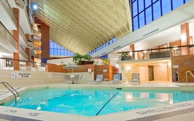 Relaxing indoor pool with lounge chairs at the Holiday Inn Oakville Centre.