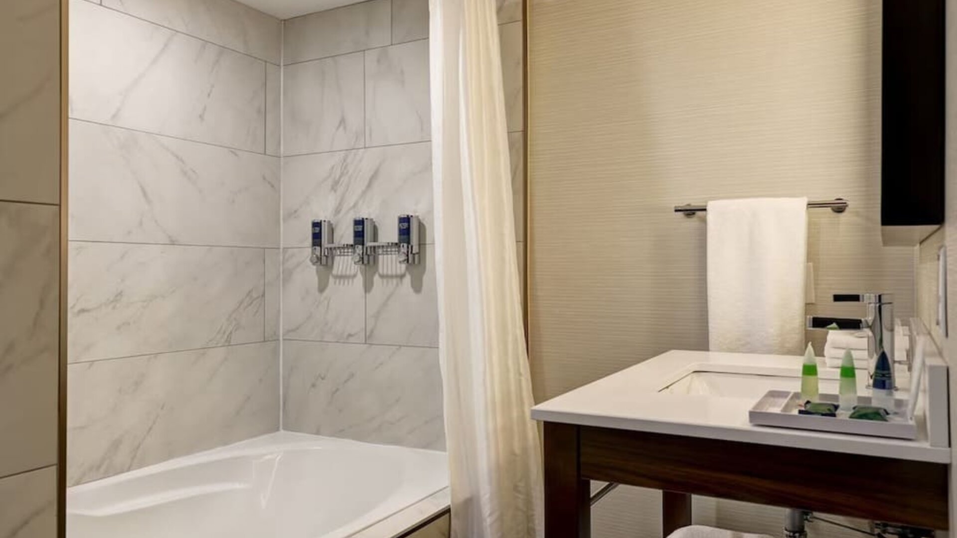 Private guest bathroom with tub and free toiletries at the Four Points By Sheraton St Catharines Niagara Suites.