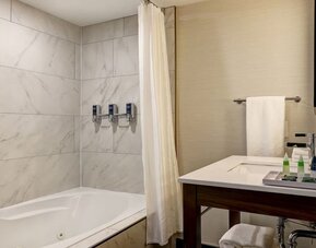 Private guest bathroom with tub and free toiletries at the Four Points By Sheraton St Catharines Niagara Suites.
