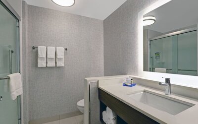 Private guest bathroom with shower and free toiletries at Holiday Inn Express Kingston West.