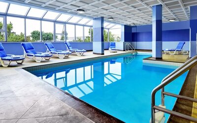 Relaxing indoor pool with lounge chairs at Four Points By Sheraton Toronto Mississauga.