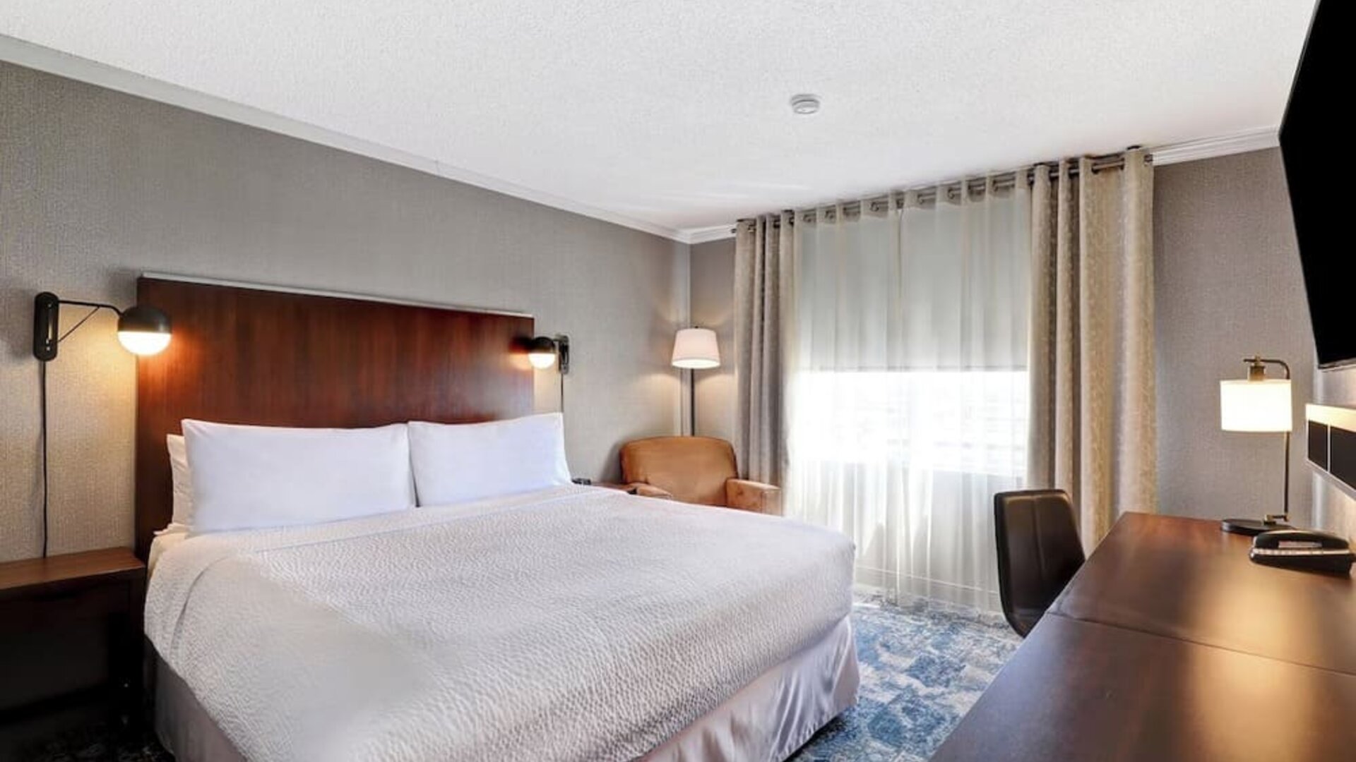 Day use room with TV, sofa, work desk and private bathroom at Four Points By Sheraton Toronto Mississauga.