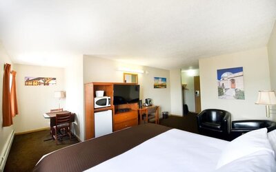 Day use room with TV, tables, sofas, mini bar, microwave and private bathroom at Riviera Motor Inn.