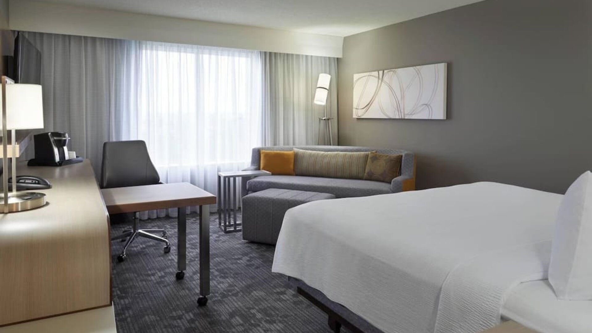 Bright day use room with TV, sofa, work desk and private bathroom at Courtyard By Marriott Toronto Airport.