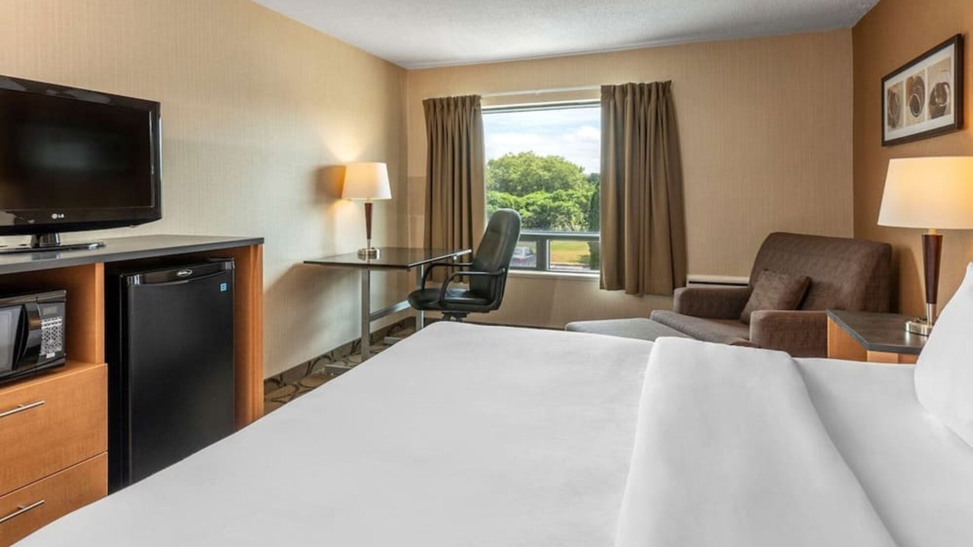 Day use room with TV, sofa, work desk and private bathroom at Comfort Inn Sept-Iles. 