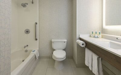 Guest bathroom with tub and shower at Holiday Inn Express & Suites North Bay.