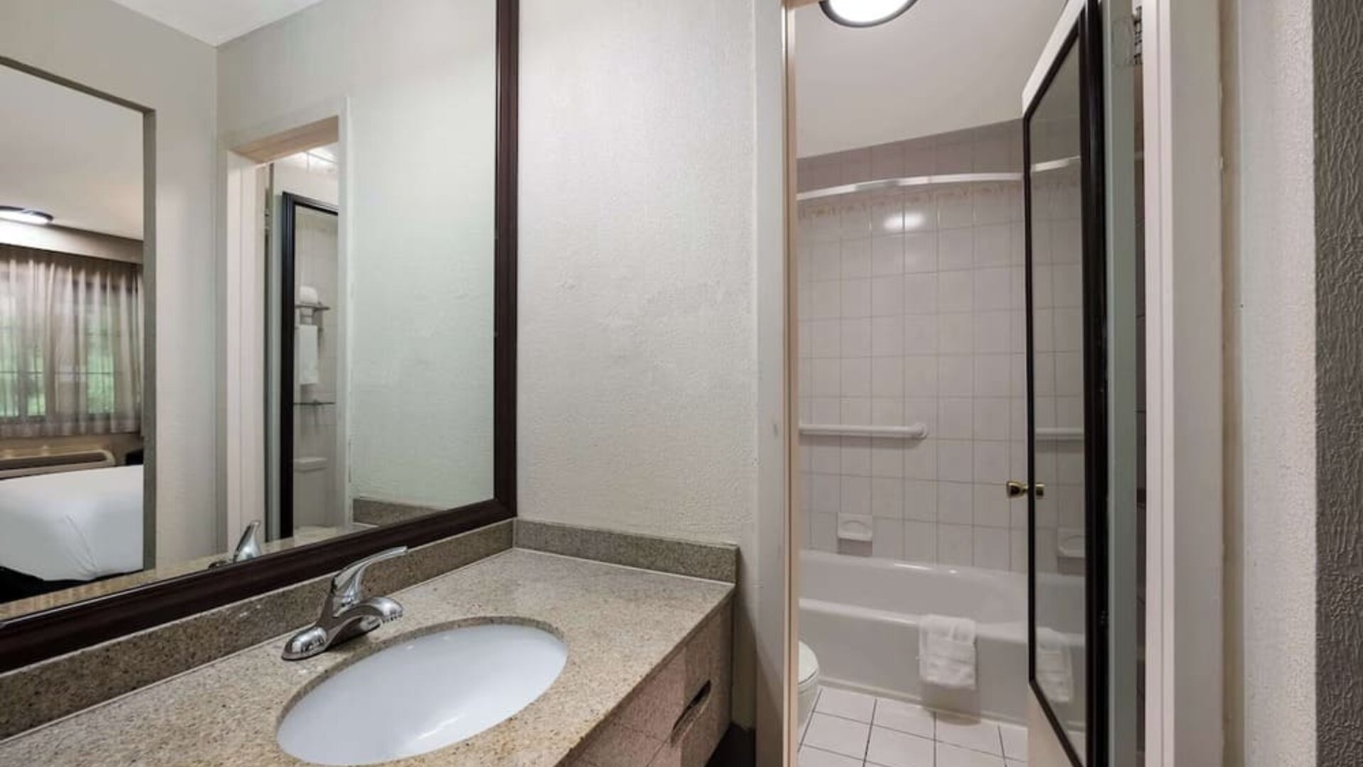 Guest bathroom with shower and tub at Best Western Woodbury Inn.