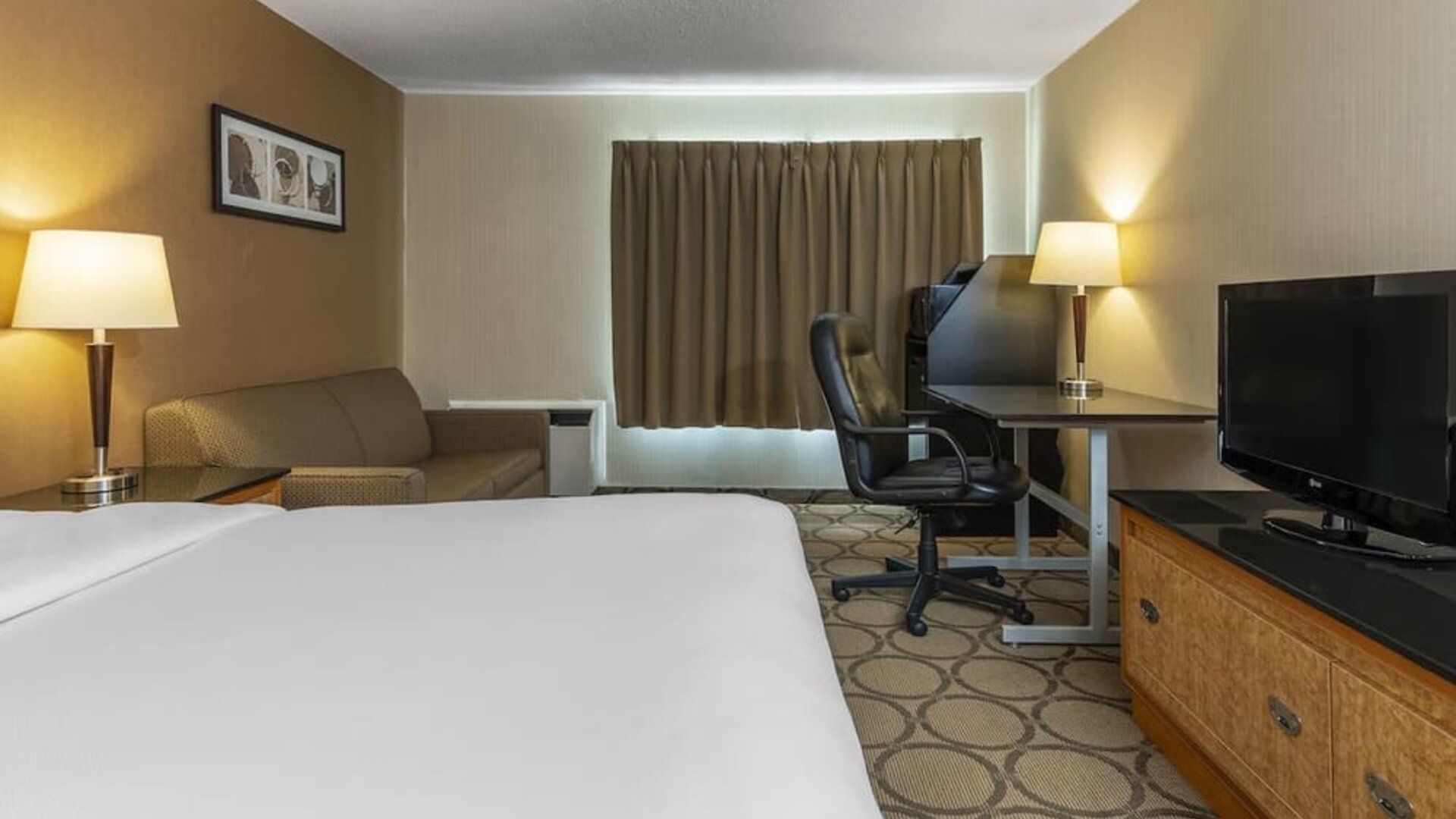 Day use room with TV, work desk, sofa and private bathroom at Comfort Inn Orillia.