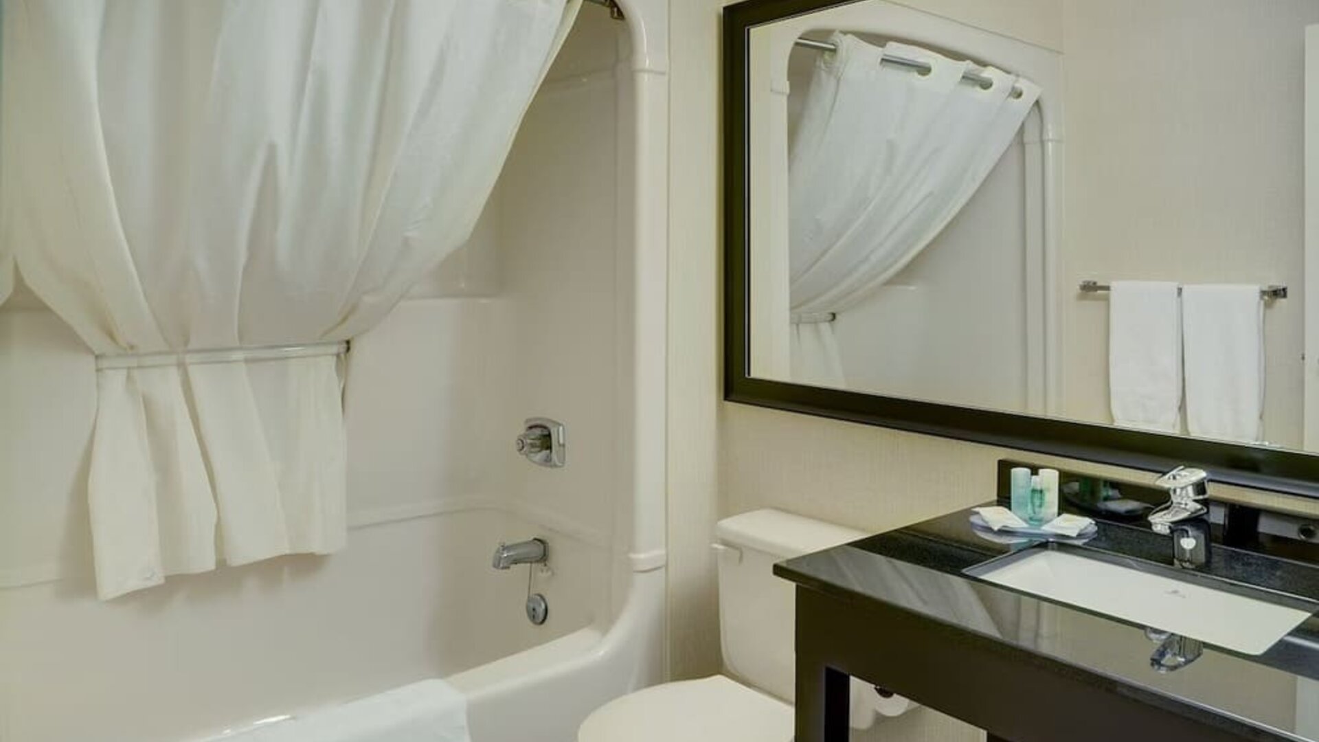 Guest bathroom with tub and free toiletries at Comfort Inn Chicoutimi.