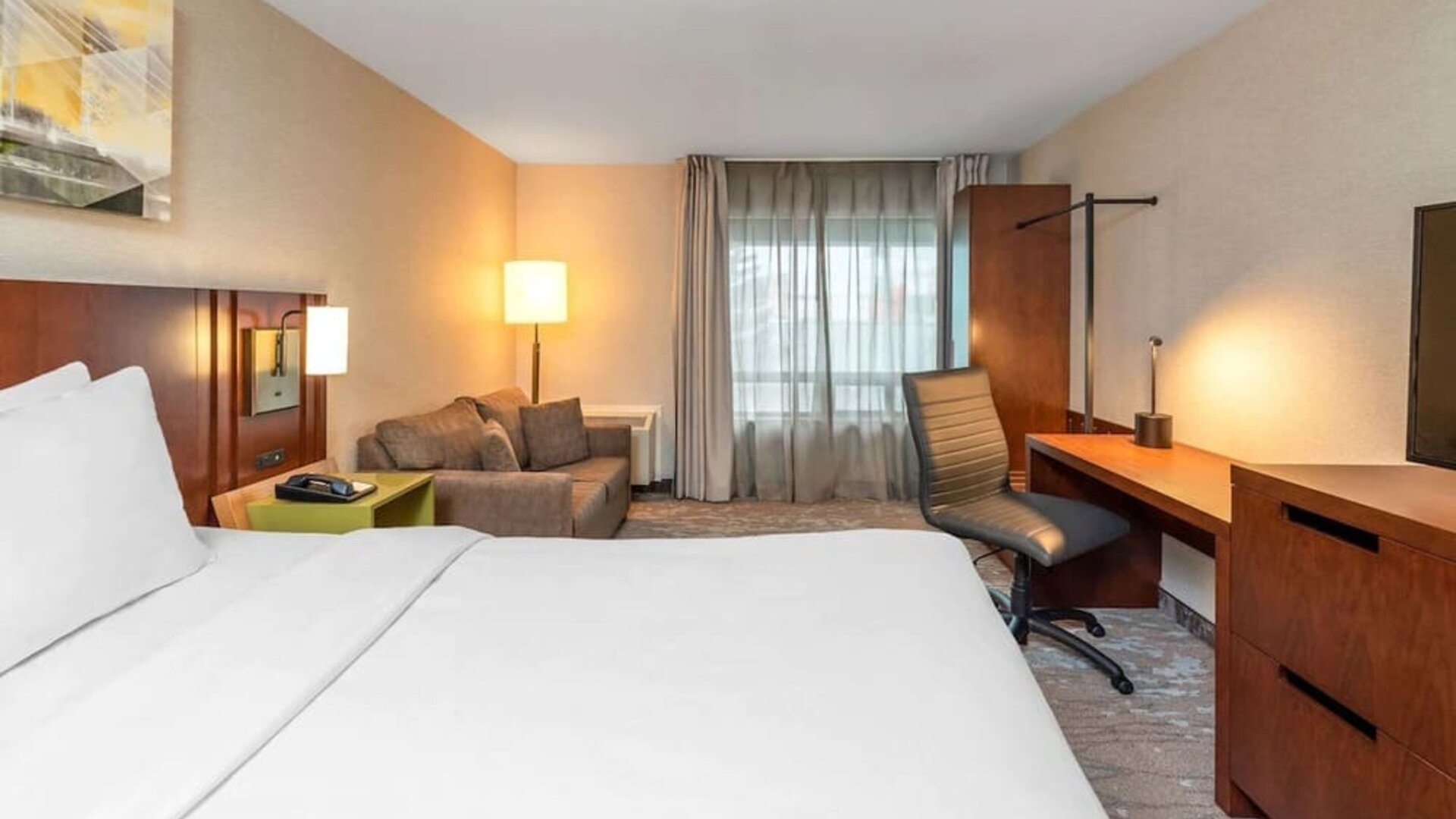 Day use room with work desk and sofa at Comfort Inn Boucherville.