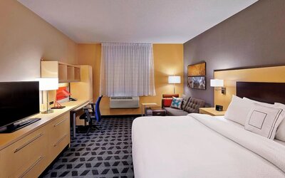 Day use room with TV, work desk and sofa at TownePlace Suites By Marriott London.