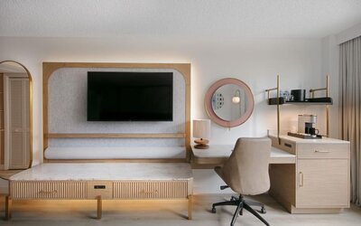 Day use room's workspace with TV screen and workdesk with ergonomic chair at Sonesta Miami Airport.