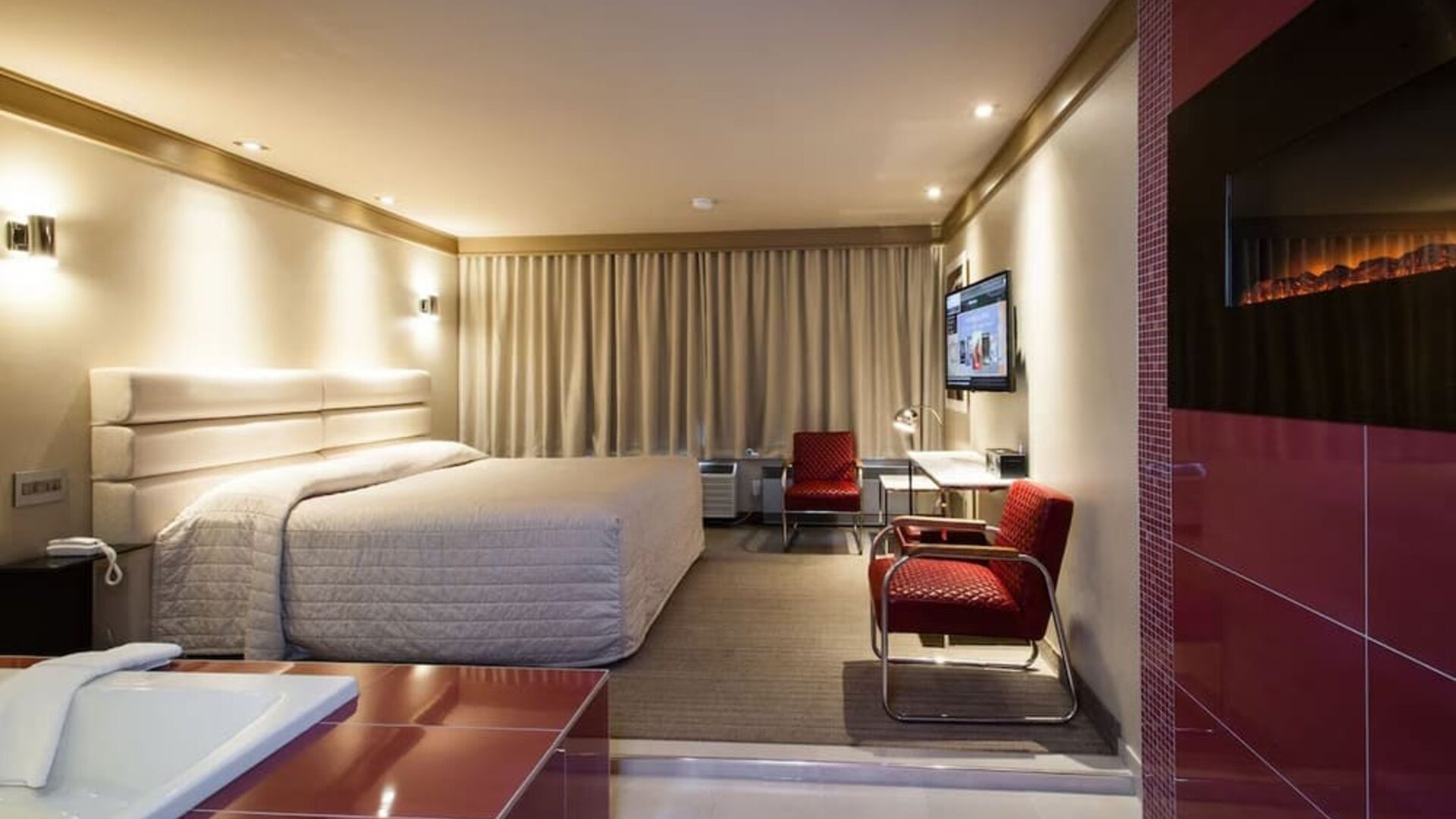 Junior suite with work desk, fireplace and hot tub at Le Chabrol Hotel Et Suites.