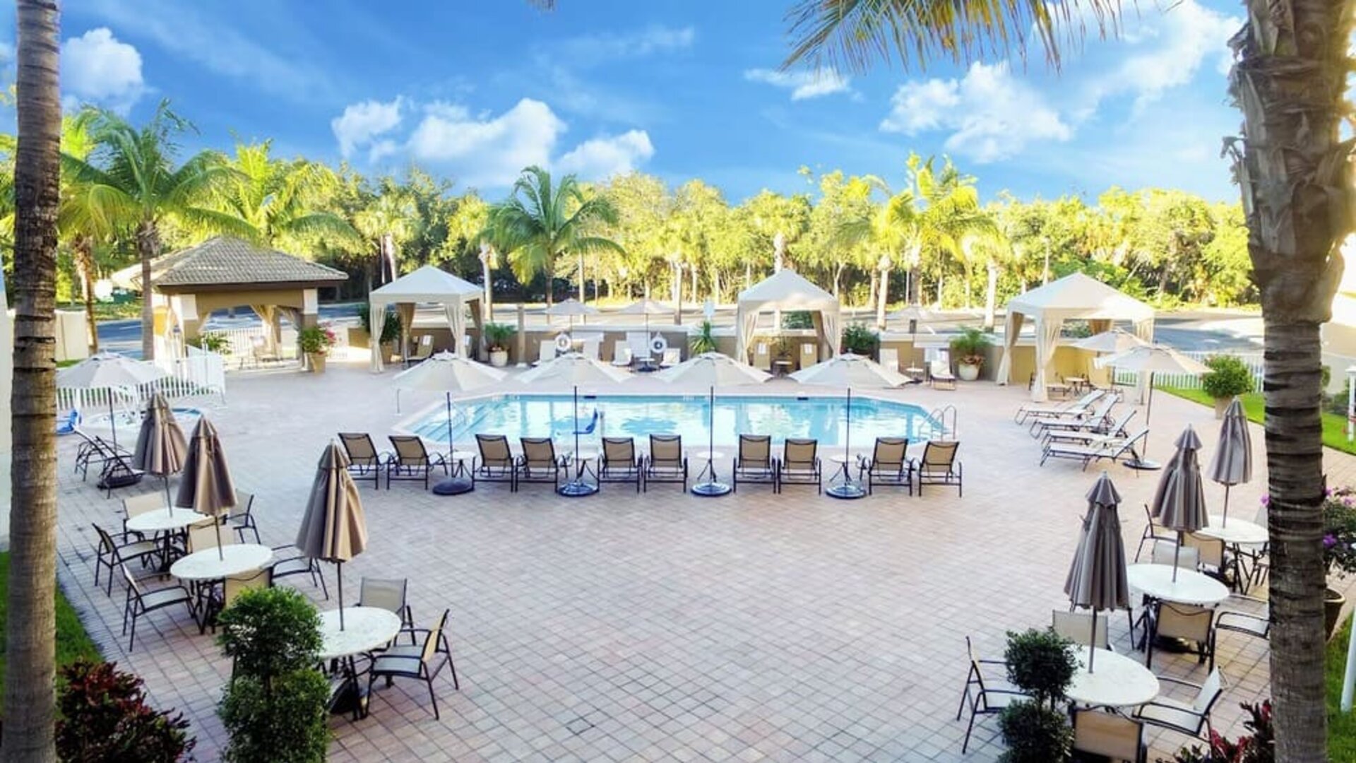 Sun loungers surrounding the pool at Holiday Inn Express & Suites Naples Downtown - 5th Avenue.