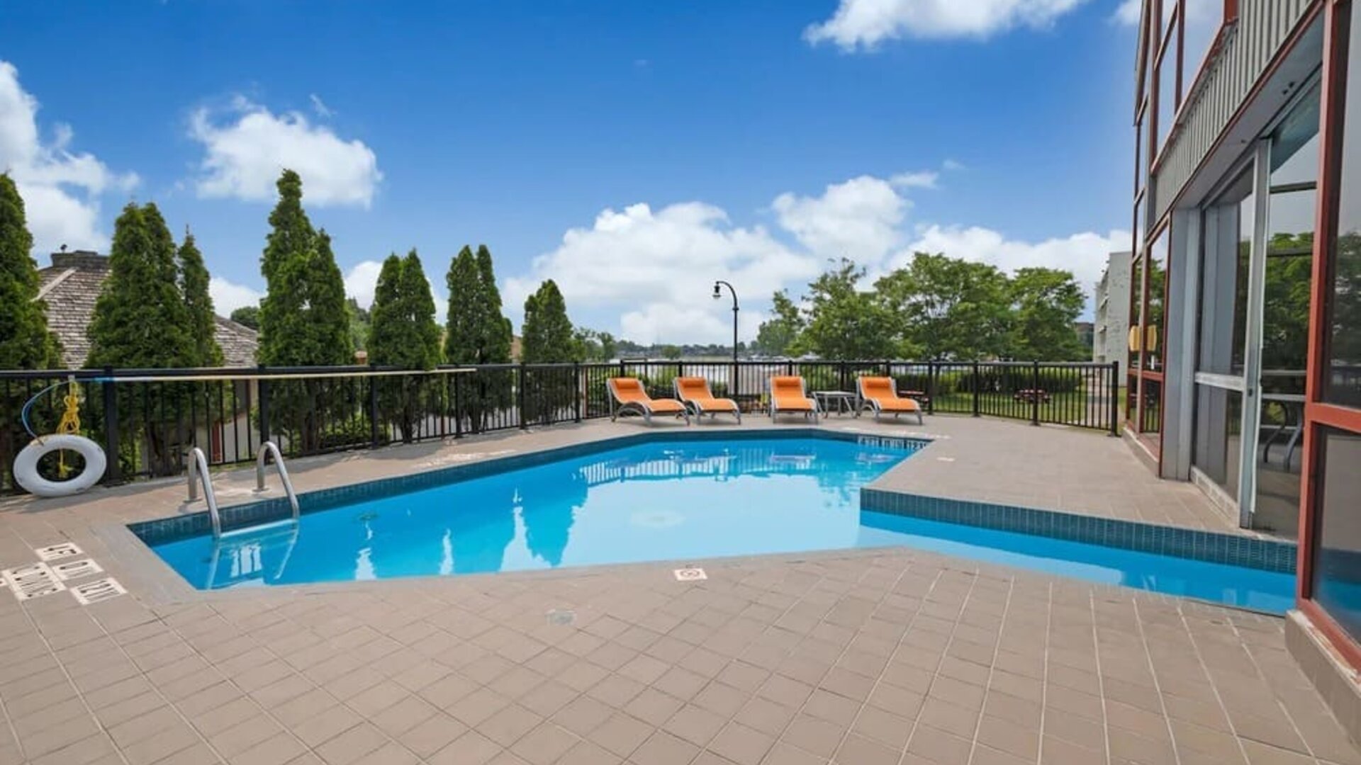 Hotel terrace with outdoor pool and lounge chairs at Holiday Inn Peterborough-Waterfront.