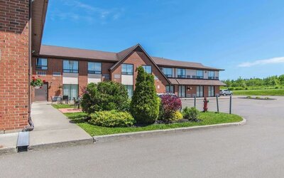 Hotel exterior with lounge seating and parking area at Comfort Inn Moncton Magnetic Hill.