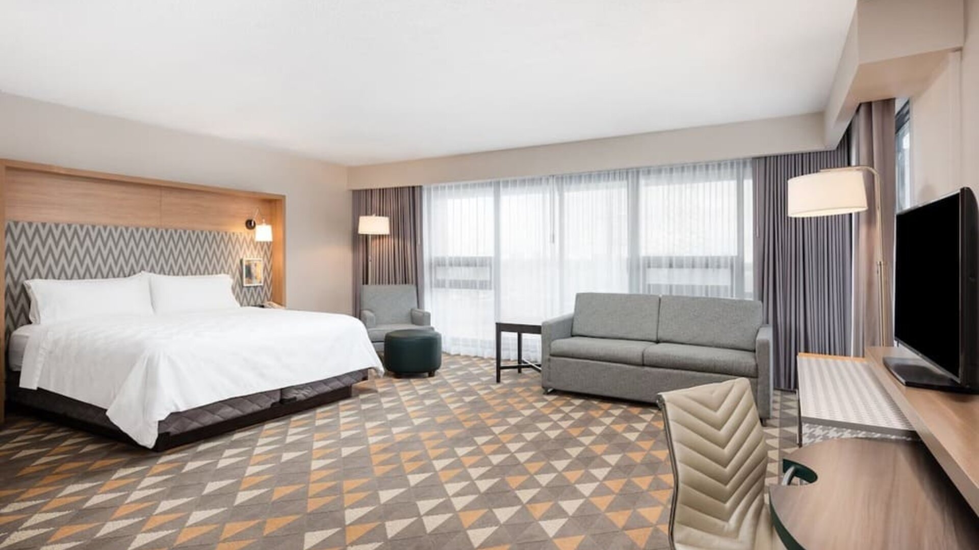 Bright and spacious king room with work desk and sofa at Holiday Inn Toronto Airport East.