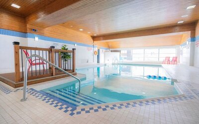 Relaxing indoor pool with lounge seating at Les Suites Hotel Ottawa.