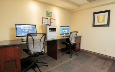 Business center with computers, printer and ergonomic chairs at Les Suites Hotel Ottawa.