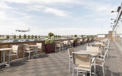 Hotel terrace with comfortable seating and airport view at Thistle London Heathrow Terminal 5.