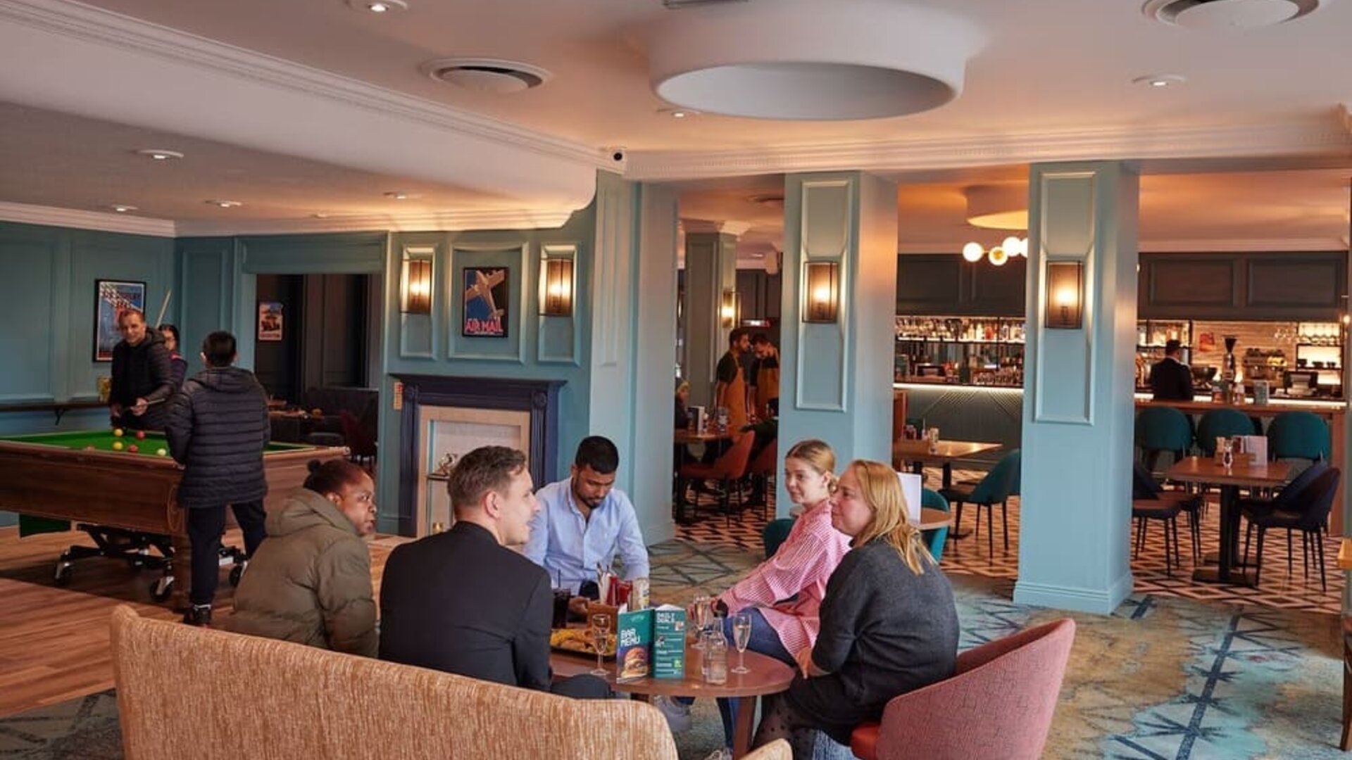Dining area with comfortable seating and billiards at Thistle London Heathrow Terminal 5.