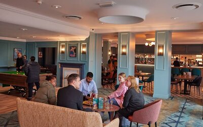Dining area with comfortable seating and billiards at Thistle London Heathrow Terminal 5.