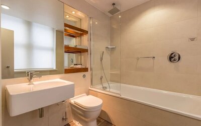 Guest bathroom with tub and free toiletries at Thistle Holborn, The Kingsley Hotel.