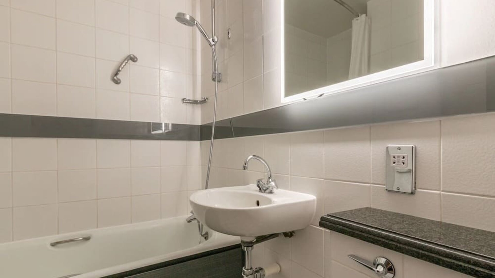 Guest bathroom with combined tub and shower at Thistle Express London, Luton.