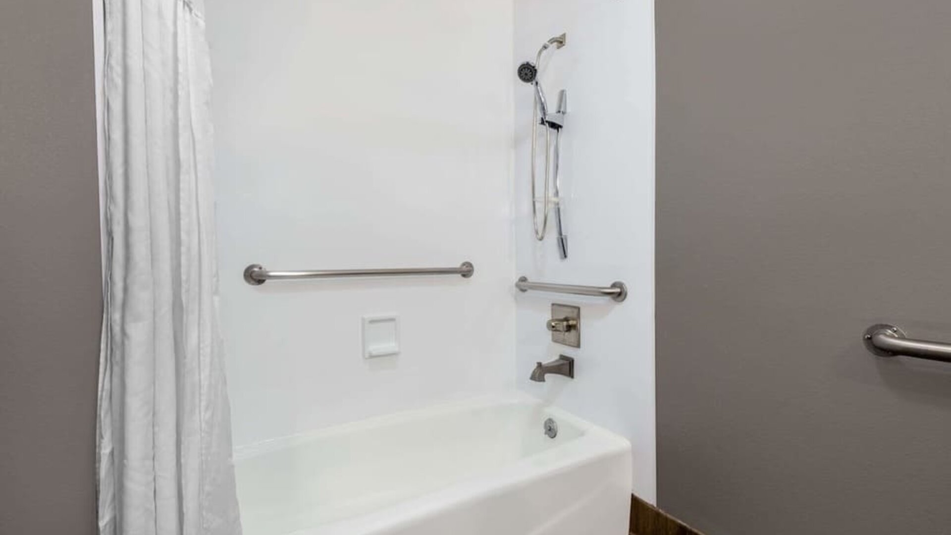 Guest bathroom with combined tub and shower at Hotel 1550 SFO.