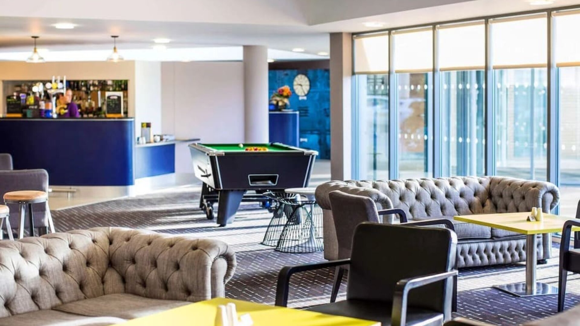 Hotel bar with lounge seating and billiards at Ibis Styles Barnsley.
