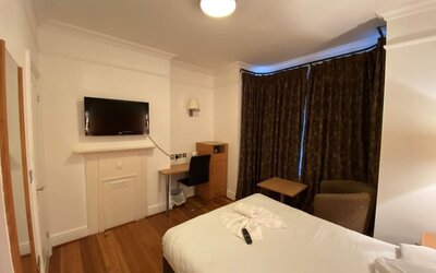 Day use room with TV screen and work desk at Buckingham Hotel.